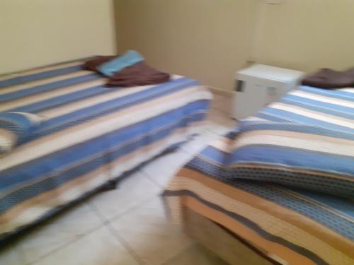 twee bedden naast elkaar in een kamer bij Espaço antonela e Ana livia in Aparecida