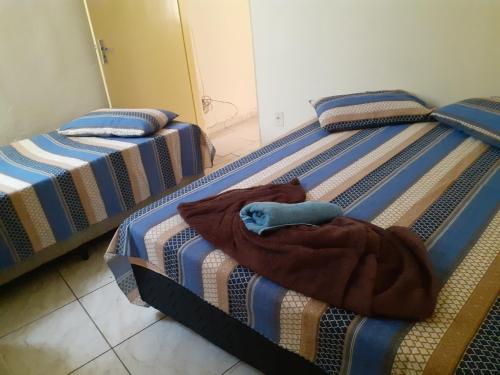 two twin beds in a room with a blanket at Espaço antonela e Ana livia in Aparecida