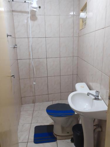 a bathroom with a toilet and a sink and a shower at Espaço antonela e Ana livia in Aparecida