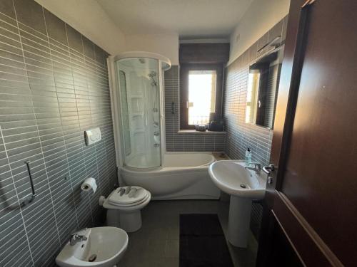 a bathroom with a sink and a toilet and a bath tub at Appartamento del Parco in Lunghezza