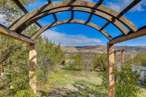 an archway over a field with mountains in the background at Outdoor Kitchen Mtn-View Morongo Valley Cabin! in Morongo Valley