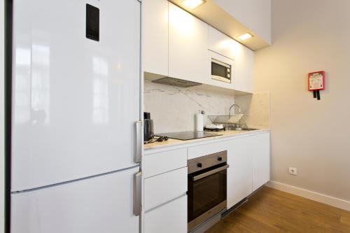 a kitchen with white cabinets and a stove at RVA - Porto Central Flats in Porto
