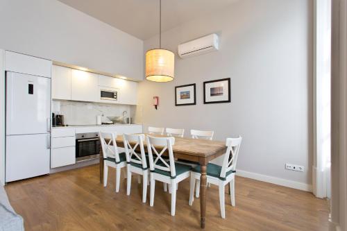 a kitchen and dining room with a wooden table and chairs at RVA - Porto Central Flats in Porto