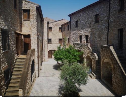un callejón con edificios de piedra y un árbol en el medio en La Tana Dell'OLMO en Fondi