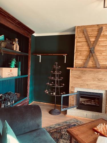 a living room with a christmas tree next to a fireplace at Refúgio do Mezio in Mezio