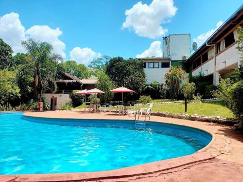 a pool with chairs and umbrellas in front of a house at HOTEL LA TOSCANA in San Ignacio