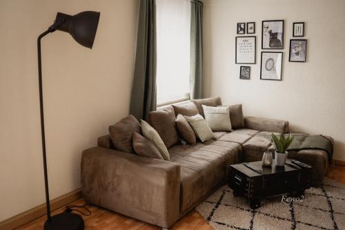 a living room with a brown couch and a lamp at Lieblingsplatz by Julia & Tom in Kesselsdorf