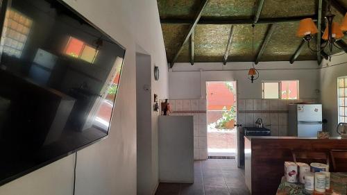 a kitchen with a flat screen tv on a wall at Refugio Renacer in Pisco Elqui