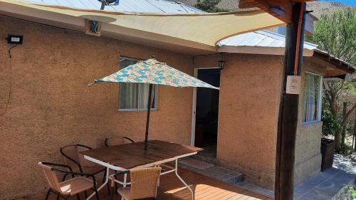 a table and chairs with an umbrella on a patio at Refugio Renacer in Pisco Elqui