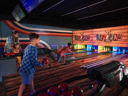 um grupo de pessoas jogando boliche em uma pista de boliche em Great Wolf Lodge Concord em Concord