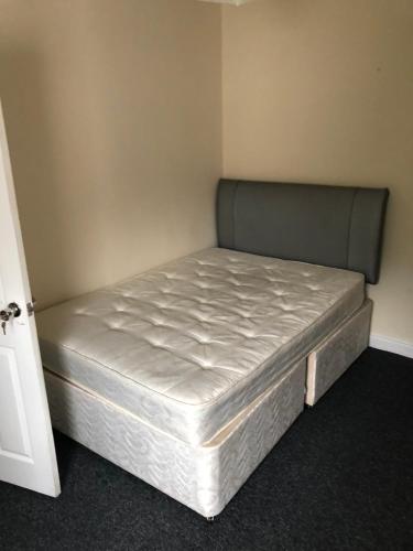 a bed in a corner of a room at Cozy stanford place in Wolverhampton