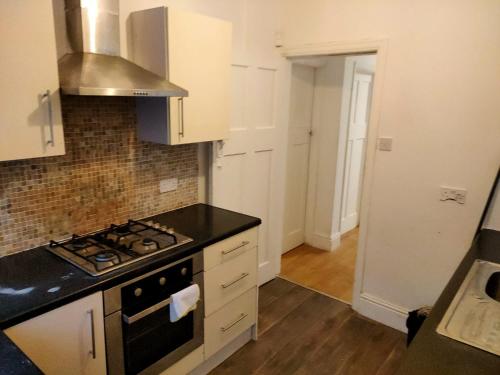 a kitchen with a stove top oven next to a door at Cozy stanford place in Wolverhampton