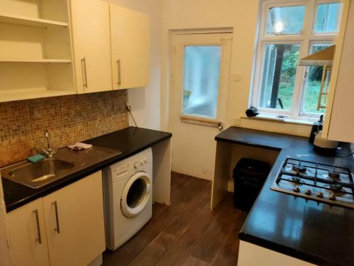 a kitchen with a sink and a washing machine at Cozy stanford place in Wolverhampton