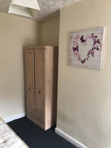 ein Schlafzimmer mit einer Kommode und einem Wandgemälde in der Unterkunft Cozy stanford place in Wolverhampton