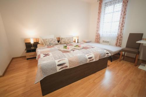 a bedroom with a large bed with a wooden floor at Pension Štěpán in Mikulov