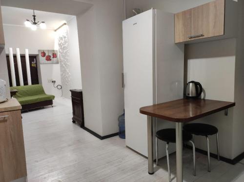 a kitchen with a table and a refrigerator at BANDERA Hostel in Lviv