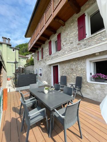 un patio con mesa y sillas en una terraza de madera en L' aurora, en Pieve Tesino