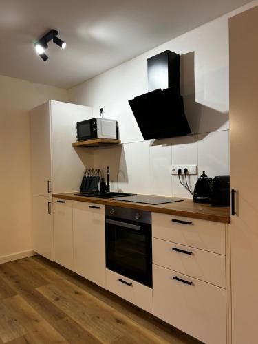 a kitchen with white cabinets and a stove top oven at Veselé Apartmány Lipno in Lipno nad Vltavou