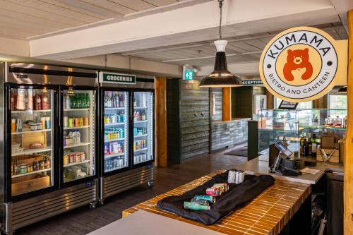 a restaurant with a counter with a drink refrigerator at Pine Bungalows in Jasper