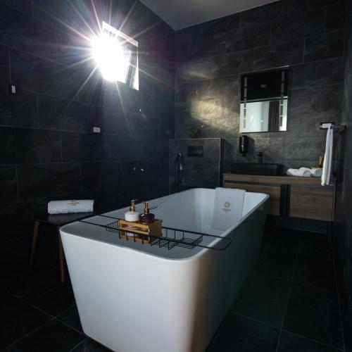 a bathroom with a bath tub with a light on it at Harmonija SPA RESORT in Vrdnik