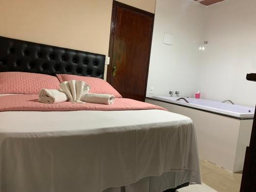 a bedroom with a large bed with a bath tub at Pousada Recanto do Chalé Ltda in Macacos