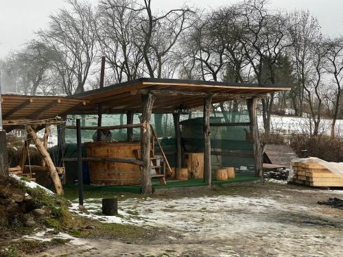 cobertizo con techo de madera y barril en Pensiunea Teodora Breb Maramu en Breb