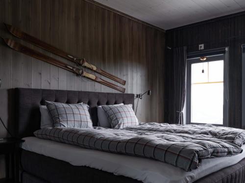 a large bed in a bedroom with a window at Åre Valley Lodges - Kopparvillan in Åre