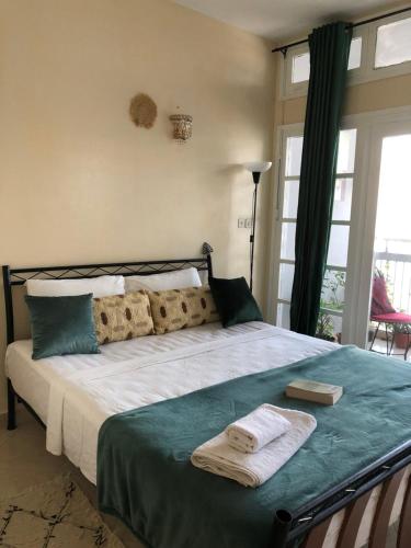 1 dormitorio con 1 cama con 2 toallas en Appart Alhambra, en Rabat