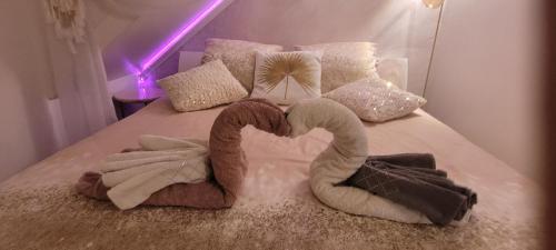 a bed with two towels in the shape of a heart at Au Fil De l' Eau in Aurec-sur-Loire