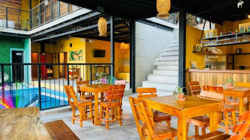 a restaurant with wooden tables and chairs and stairs at Coffee House Minca in Minca