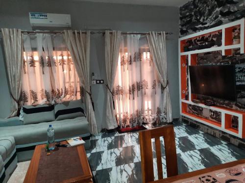 sala de estar con sofá y TV en Résidence kenzaina, en Ouagadougou