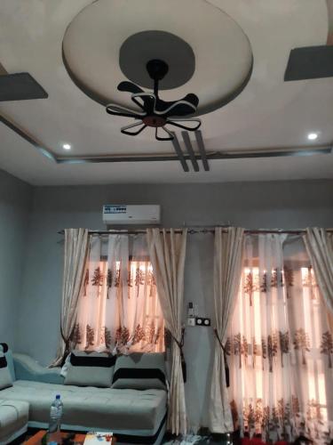 a ceiling fan in a living room with a couch at Résidence kenzaina in Ouagadougou