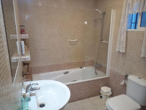 y baño con lavabo, bañera y aseo. en Apartamento Tahalia 3 habitaciones, en Huelva