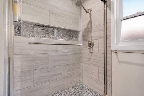 een badkamer met een douche met een glazen deur bij Modern home near colleges in Claremont