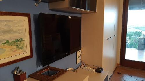 Elle comprend une grande télévision à écran plat suspendue au mur. dans l'établissement La Finestra su Stintino 2, à Stintino