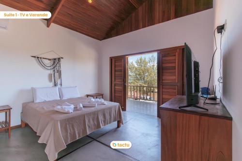 1 dormitorio con 1 cama, TV y balcón en Apto 100m da praia no Pontal de Maceió por Tactu, en Fortim