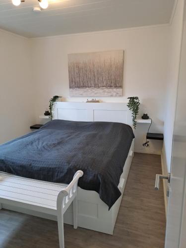 a bedroom with a white bed with a black blanket at Küstenblick Marienleuchte in Fehmarn