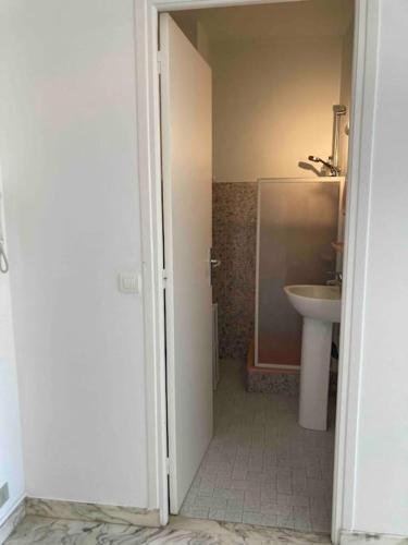 - une porte ouverte donnant sur une salle de bains avec lavabo dans l'établissement Studio vue mer, 10 min de Monaco !, à Roquebrune-Cap-Martin