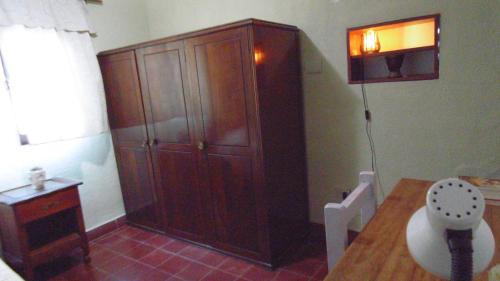 Habitación con un gran armario de madera. en Albergue Casa Elena en San Miguel de Tucumán