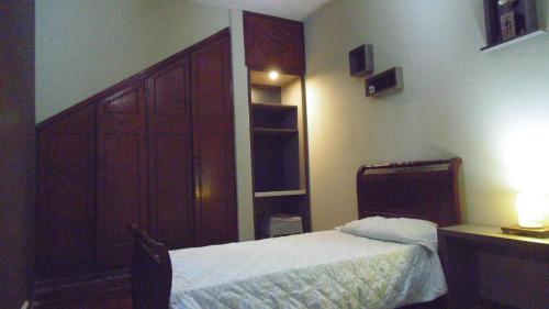 1 dormitorio con 1 cama, vestidor y escritorio en Albergue Casa Elena en San Miguel de Tucumán