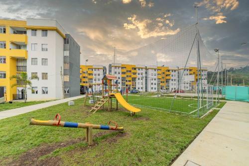 a playground with a slide and a swing at Moderno apartamento primer piso in Dosquebradas