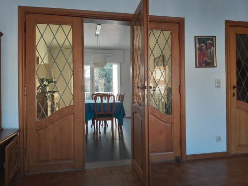 a dining room with wooden doors and a table with chairs at Joseph(ine) in Antwerp