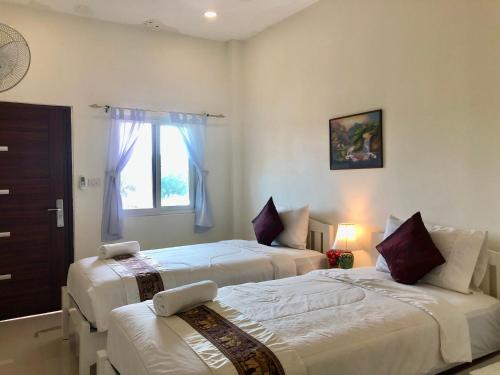 1 dormitorio con 2 camas y ventana en Naraya Homestay, en San Pa Tong