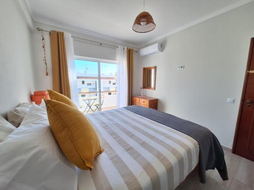 a bedroom with a bed with a large window at AREIAS SOL in Albufeira