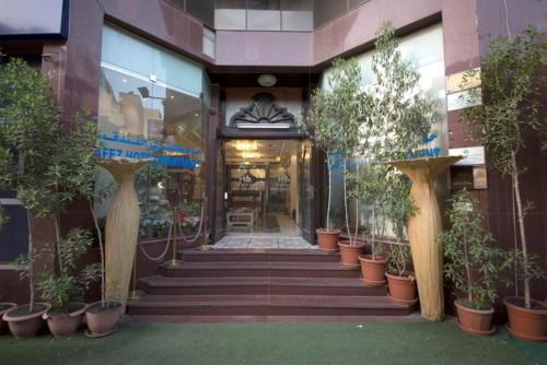 a building with a bunch of potted plants on the stairs at Hafez Hotel Apartments - Al Ras Metro Station in Dubai