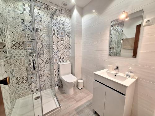 a bathroom with a shower and a toilet and a sink at AREIAS SOL in Albufeira