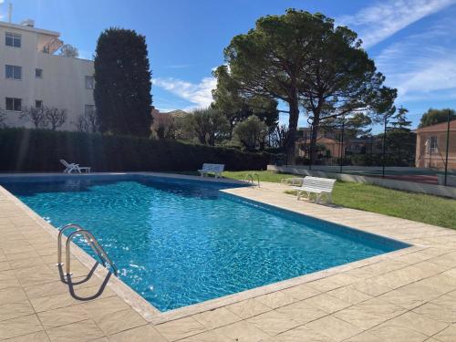 une piscine avec de l'eau bleue dans une cour dans l'établissement Studio vue mer, 10 min de Monaco !, à Roquebrune-Cap-Martin
