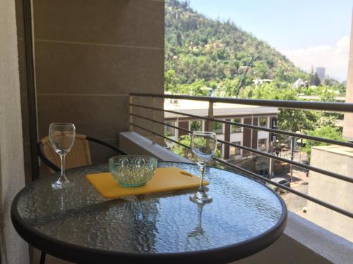 una mesa con 2 copas de vino en el balcón en BELLAVISTA DARDIGNAC, en Santiago