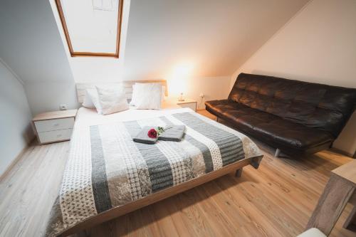 a bedroom with a bed and a leather couch at Pension Štěpán in Mikulov