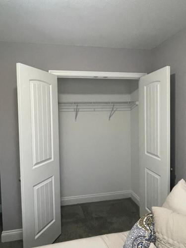 a bedroom with a closet with white doors and a bed at Bloom’s Retreat in Norfolk